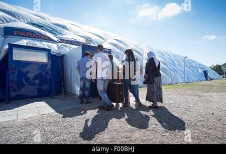 Taufkirchen, Deutschland. 5. August 2015. Eine Familie geht auf den Eingang zu einer Traglufthalle derzeit tätig als Flüchtling Unterkunft in Taufkirchen, Deutschland, 5. August 2015. Foto: PETER KNEFFEL/Dpa/Alamy Live News Stockfoto