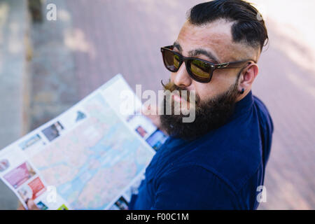 bärtiger Mann mit einer Karte in der hand Stockfoto