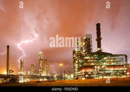 Gewitter und Blitz stürzt über aufgehellte petrochemische Industrie im Hafen von Antwerpen in der Nacht, Belgien, Antwerpen Stockfoto