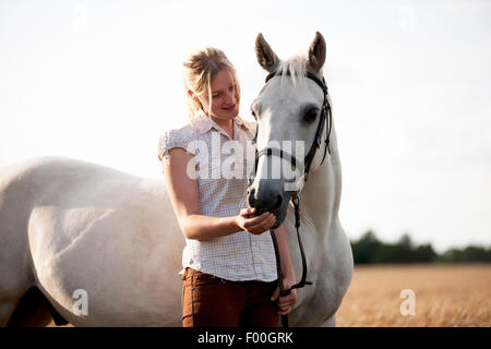 Eine junge Frau streicheln ein Grauschimmel Connemara Stockfoto