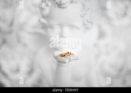 Zwei Trauringe in der Hand des Engels, Nahaufnahme Foto Stockfoto