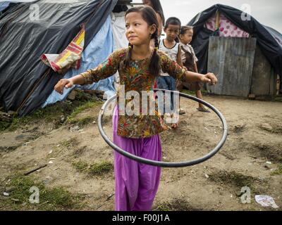 Kathmandu, Nepal. 5. August 2015. Eine Mädchen spielt mit einem hausgemachten '' Hula Hoop'' Art Spielzeug in eine große interne Vertriebene (IDP) Lager im Zentrum von Kathmandu. Das Camp ist neben einer der teuersten internationalen Hotels in Kathmandu. Mehr als 7.100 durch das Erdbeben in Nepal im April vertriebene Menschen leben in 1.800 Zelte verteilt über den Raum von drei Fußballfeldern. Im Camp gibt es keinen Strom. Bildnachweis: ZUMA Press, Inc./Alamy Live-Nachrichten Stockfoto