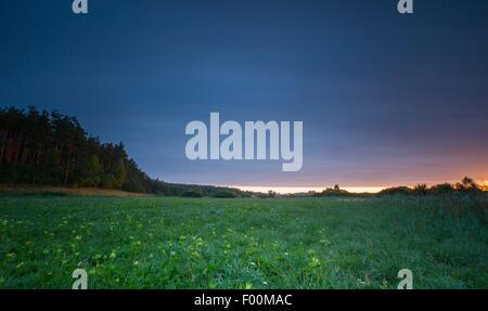 Schönen Sonnenaufgang über dem nebligen Wiese. Bewölkter Himmel mit vielen Farben über morgen Wiese im Sommer. Stockfoto