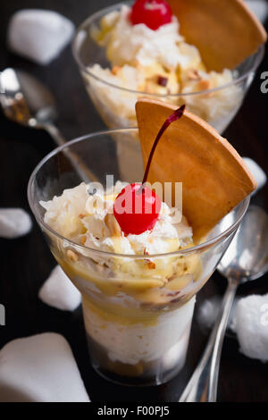 Durian-Eis mit Kirschen und Waffel auf schwarzem Holz Hintergrund Stockfoto