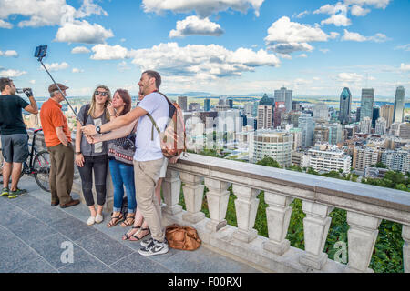 Touristen, die mit einem Selfie stick vor der Skyline von Montreal, Kondiaronk Belvedere. Stockfoto