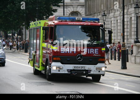 EIN ROTER MERCEDES-BENZ LONDON FEUERWEHRAUTO FAHREN ENTLANG EINER HAUPTSTRAßE IM ZENTRUM VON LONDON Stockfoto