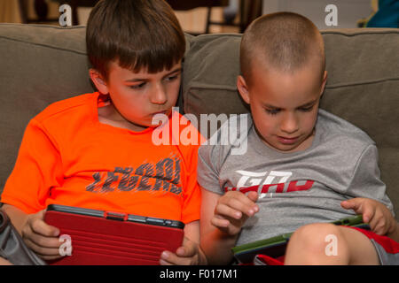 Zwei Brüder spielen Spiele auf ihren iPads.  HERR Stockfoto