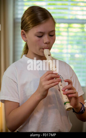 Junges Mädchen (11 Jahre alt) üben die Blockflöte zu spielen.  HERR Stockfoto