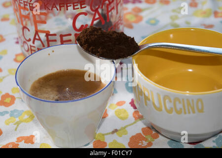 eine Tasse extra starken Kaffee mit einem Teelöffel des gemahlenen Kaffees Stockfoto