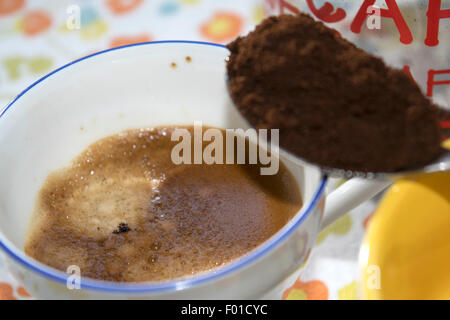 eine Tasse extra starken Kaffee mit einem Teelöffel Zahlschwein Kaffee Stockfoto