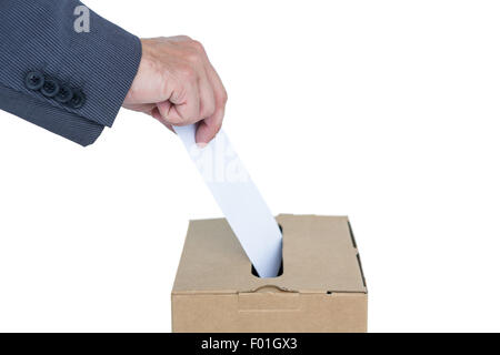 Geschäftsmann, die Stimmzettel in Abstimmung Feld setzen Stockfoto