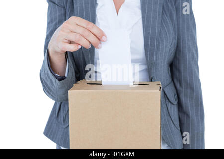 Geschäftsmann, die Stimmzettel in Abstimmung Feld setzen Stockfoto