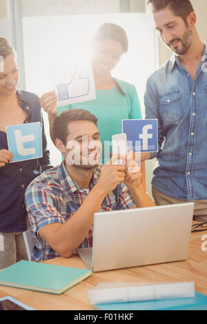 Kollegen mit Schild aus bekannten sozialen Netzwerken Stockfoto