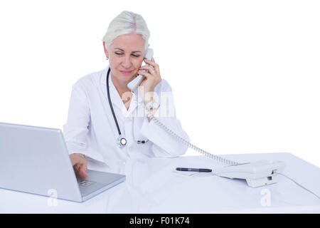 Arzt arbeitet auf ihrem Laptop und auf dem Handy Stockfoto