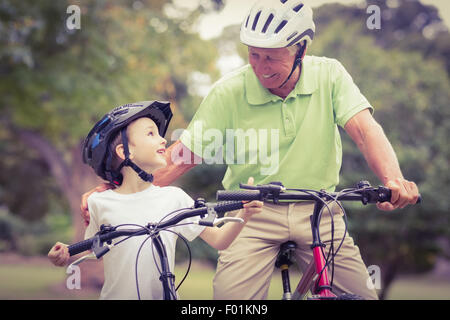 Glücklich Opa mit seiner Enkelin auf ihr Fahrrad Stockfoto