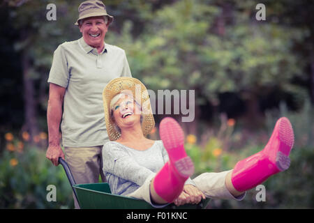 Gerne älteres Paar spielen mit einer Schubkarre Stockfoto