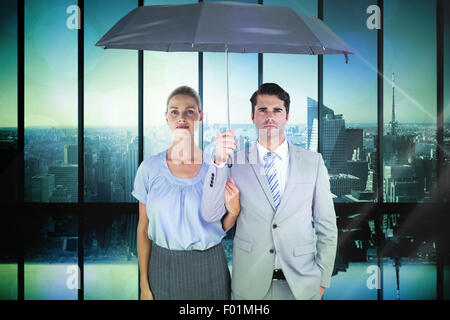 Zusammengesetztes Bild von Geschäftsleuten hält einen schwarzen Regenschirm Stockfoto