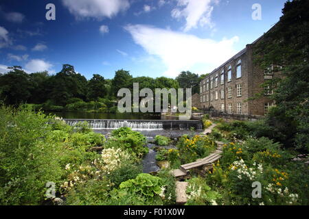 Ein Holzsteg überspannt den Fluss Derwent Bamford Mill und Wehr, Bamford, Peak District, Derbyshire England uk - Sommer Stockfoto