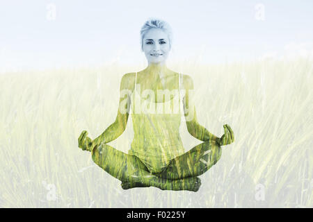 Zusammengesetztes Bild von getönten junge Frau sitzt in Lotus-pose Stockfoto