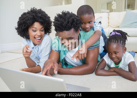 Glückliche Familie, die auf dem Boden liegend Stockfoto