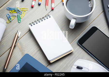 Notizblock neben die Tasse Kaffee Smartphone Maus und tablet Stockfoto