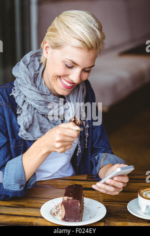 Lächelnde Blondine ein Stück Schokoladenkuchen Stockfoto