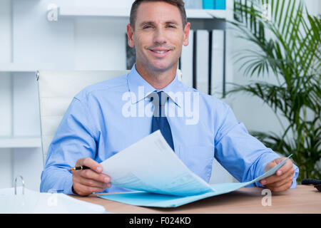 Lächelnde Geschäftsmann eine Contrat zu lesen, bevor Sie ihn unterschreiben Stockfoto