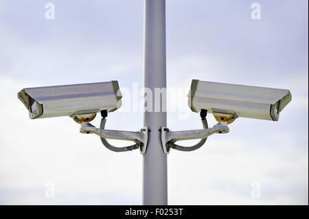 Zwei Überwachungskameras auf einem Mast mit blauen Himmel im Hintergrund Stockfoto