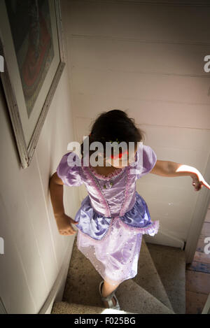 Fünf Jahre altes Mädchen in einem Kostümfest, beim Treppensteigen Stockfoto