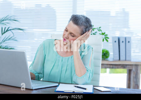 Müde Geschäftsfrau auf laptop Stockfoto