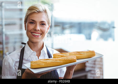 Hübsche Kellnerin mit Baguette Stockfoto