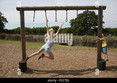 Ein junges Mädchen spielt am Apparat, Wild at Wisley Outdooraktivität Kinderspielplatz in Wisley Garden Centre, Surrey, England Stockfoto