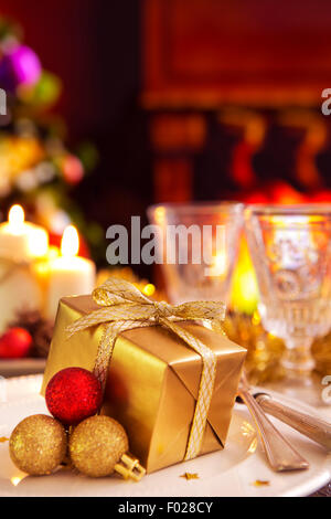 Weihnachten Tisch romantisch mit Kerzen und Weihnachtsschmuck. Im Kamin brennt ein Feuer. Stockfoto