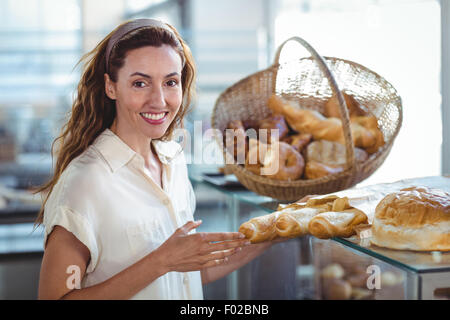 Hübsche Brünette lächelnd in die Kamera und halten Laib Brot Stockfoto