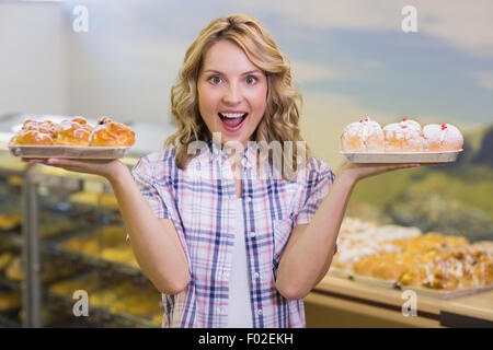 Porträt einer lächelnden blonde Frau mit einem Gebäck Stockfoto