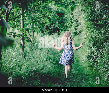 Rückansicht eines Mädchens zu Fuß durch Wald Stockfoto