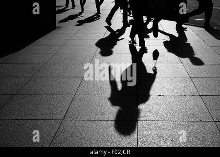 Schatten und Silhouetten von Menschen gehen auf der Straße in der Stadt Stockfoto