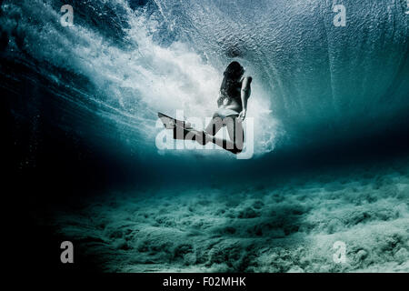 Frau schwimmt unter Wasser mit Taucherflossen, Hawaii, USA Stockfoto