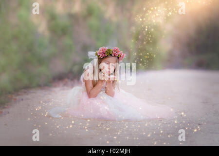 Mädchen in einem Vintage-Kleid sitzt in der Straße weht Glitter, Kalifornien, USA Stockfoto