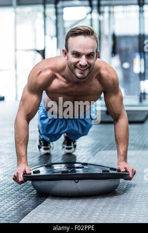 Muskulöser Mann Bosu Ball Übungen Stockfoto