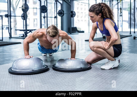 Muskulöser Mann tun Bosu Ball Push Ups Stockfoto