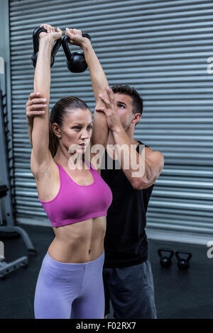 Muskuläre Trainer zeigen, wie man Kettlebells zu heben Stockfoto