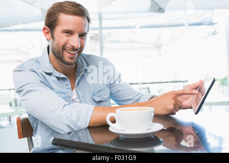 Glücklich Jüngling lächelt in die Kamera und deutete auf das Telefon Stockfoto
