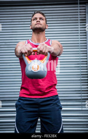 Muskulöser Mann heben eine kettlebell Stockfoto