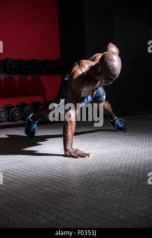 Junge Bodybuilder tun einarmigen Push Ups Stockfoto