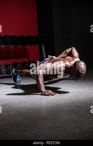 Junge Bodybuilder tun einarmigen Push Ups Stockfoto