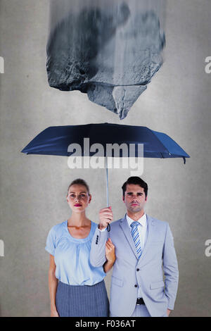 Zusammengesetztes Bild von Geschäftsleuten hält einen schwarzen Regenschirm Stockfoto