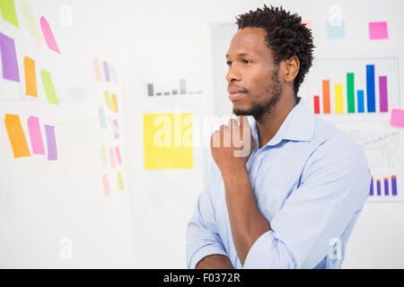 Ernsthafte Jungunternehmer Blick auf Haftnotizen Stockfoto