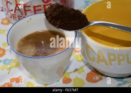 eine Tasse extra starken Kaffee mit einem Teelöffel des gemahlenen Kaffees Stockfoto