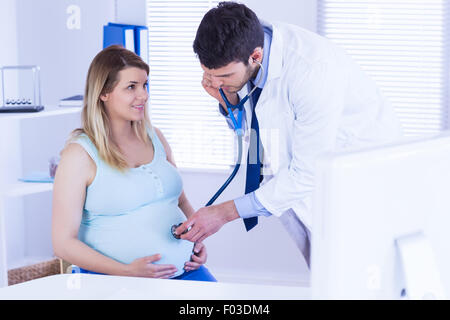 Arzt untersucht Bauch der schwangeren Patientin Stockfoto